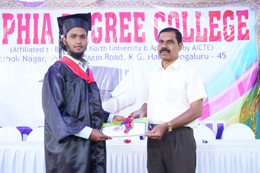 A male graduating student receiving his certificate and medal on stage.