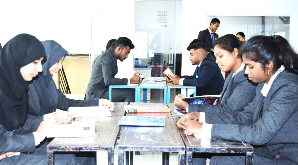 Male and female students in uniform focused on reading books at desks in the library.