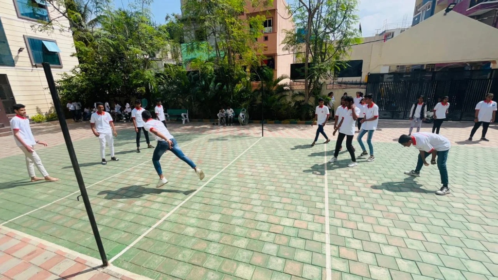 Students in white t-shirts participating in a sports game on the court.