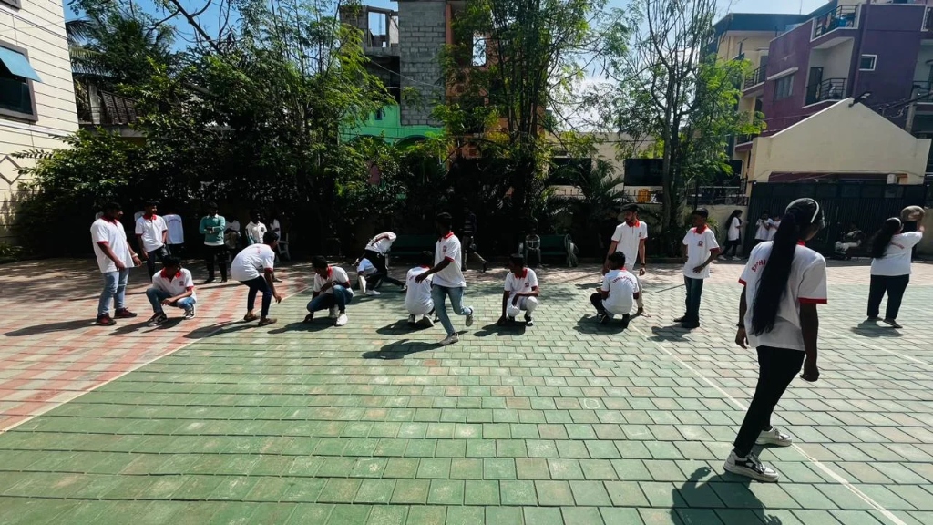 Students playing a throwball game on the sunny outdoor court.